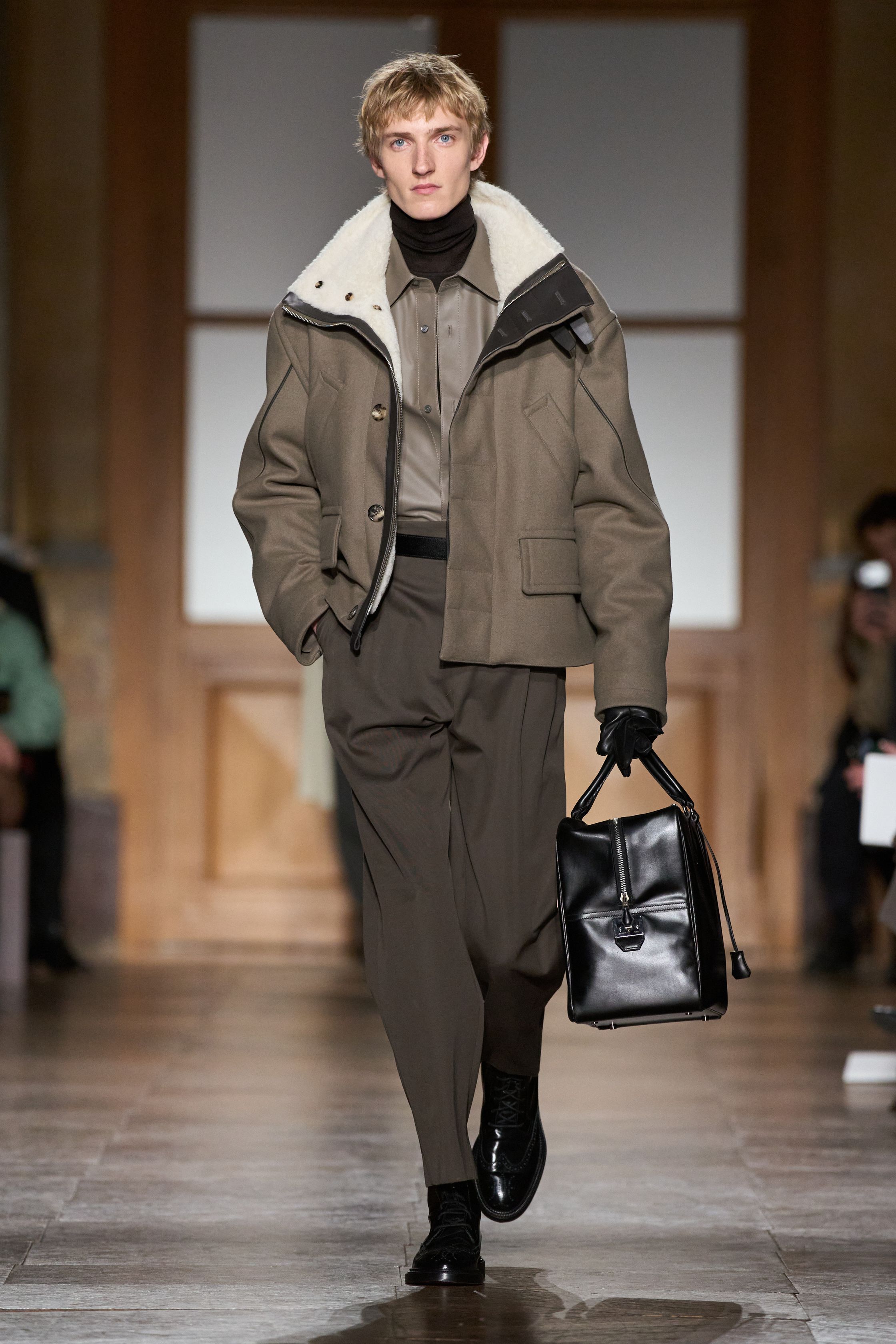 Hermès 2026秋冬以极致克制诠释当代奢华。精准剪裁、低调配色与顶级皮革共同构成安静而稳固的男性形象。黄色、防护外套与针织层次为传统正装注入功能性与轻微运动感，强调“行走中的优雅”。这是一种无需张扬的权威气质，Hermès 用时间、工艺与比例证明真正的高级并不需要宣言-顽石频道趋势研究